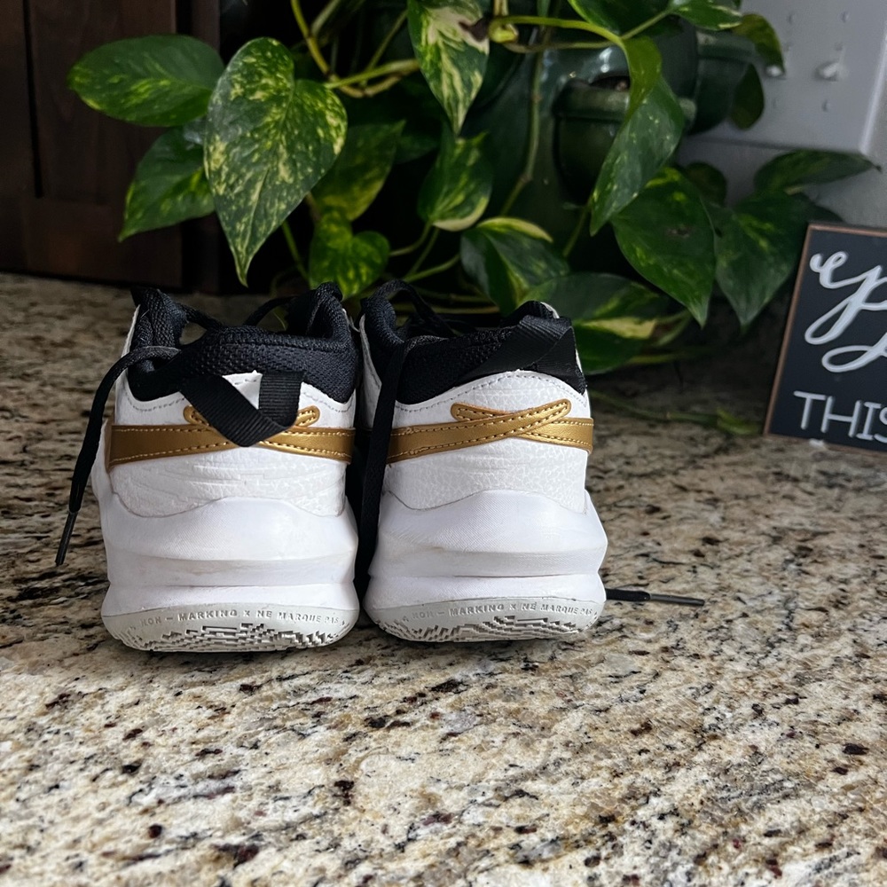 Nike HustleDX-SU21 size 5 youth slightly used gold, white, black, and grey.